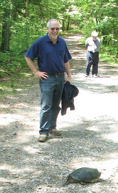 John Crawford looking at a turtle crossing the path around Cutler Lake in Needham, MA.June 4, 2009. Anatoly watches from afar.